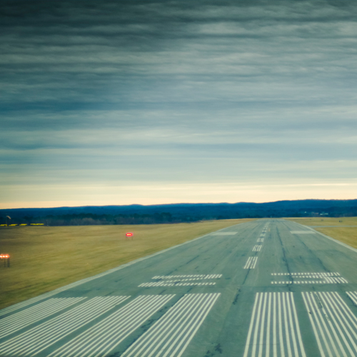 A runway stretching off into the distance, under a cloudy sky